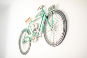 a green bike is hanging on a wall at Sagres Sun Stay - Surf Camp & Hostel in Sagres