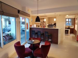 cocina y sala de estar con mesa y sillas en Hôtel Au Bon Coin, en Biarritz