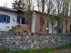 un muro di pietra di fronte a una casa di 9 Musses Hotel Apartments a Skala Mistegnon