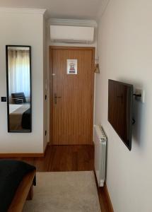 a room with a door and a mirror and a bedroom at Near the Airport in Moreira