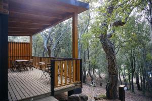 eine Holzterrasse mit einem Tisch und Stühlen darauf in der Unterkunft Camping Maçanet de Cabrenys in Maçanet de Cabrenys