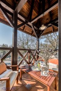 a patio with a wooden table and chairs on a porch at Apartamenty Zdrojowa in Ciechocinek