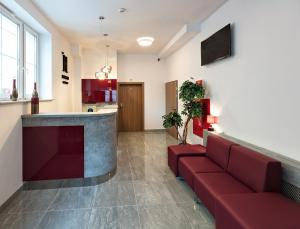 a living room with a red couch and a kitchen at HOTEL LUBLIN in Lublin