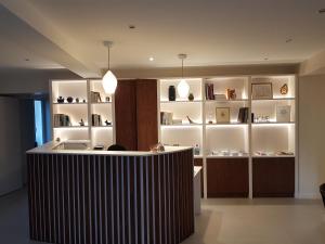 比亚里茨Hôtel Au Bon Coin的一间设有柜台和书架的房间