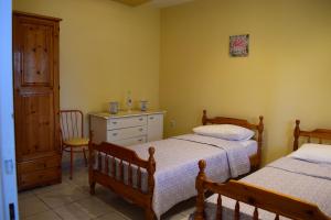 a bedroom with two beds and a dresser at AMISIANA HOUSE in Kavála