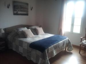 a bedroom with a bed with a blue blanket on it at Le Mas du Berger in Saint-Quentin-la-Poterie