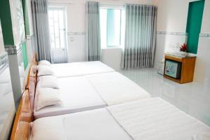 fila de camas en una habitación con TV en Thanh Sơn Motel, en Vung Tau