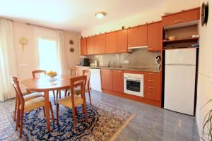 a kitchen with a table and chairs and a refrigerator at LEON INMO Chalet Arenal - 15687 in Castelló d'Empúries