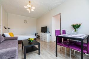 ein Wohnzimmer mit einem Tisch und lila Stühlen in der Unterkunft Compact apartment near Food Market in the Oldtown plus Free parking in Klaipėda