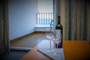 a bottle of wine and two wine glasses on a table at Hotel Selce in Selce