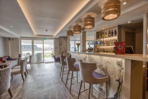 a bar in a restaurant with bar stools at La Barbarie Hotel by Eight Continents in St. Martin Guernsey