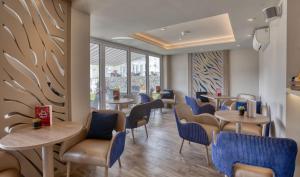 a restaurant with tables and chairs and windows at La Barbarie Hotel by Eight Continents in St. Martin Guernsey