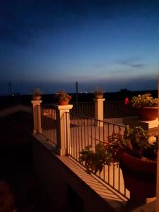 a balcony with potted plants on it at night at La Dimora del Decano in Scicli