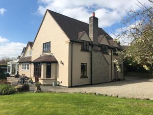 a white house with a black roof at Sayang House in Church Stretton