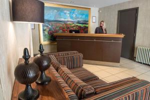 a woman talking on a phone in a waiting room at Forest Hotel in Dorridge