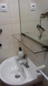 a bathroom with a sink and a mirror at Pension La Catedral in León