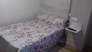 a bedroom with a bed with a floral bedspread at Pension La Catedral in León