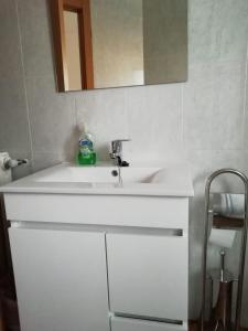 a bathroom with a white sink and a mirror at Pension La Catedral in León