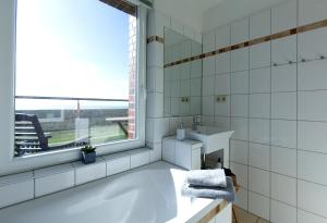 a bathroom with a tub and a sink and a window at Haus ohne Namen Juist in Juist