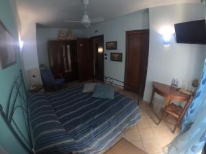 a bedroom with a bed and a table and a television at Tra... Monti E Vigne in La Morra