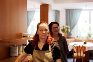 Hotel Reussischer Hof في Schmölln: اثنين من النساء واقفات في غرفة الفندق