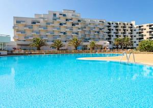 una grande piscina di fronte a un grande edificio di BARCARESA-Appartement belle vue mer piscine tennis mini golf wifi a Le Barcarès
