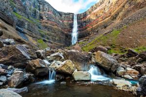 einem Wasserfall in einem Canyon mit Felsen in der Unterkunft Lyngás Guesthouse in Egilsstaðir