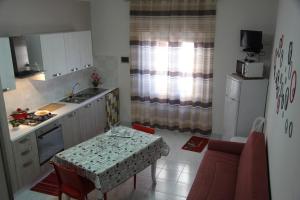 a kitchen with a table and a kitchen with a sink and a table at Cialoma Home Holiday in Scopello