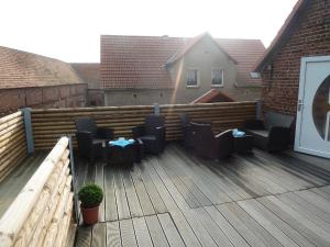 a patio with chairs and tables on a wooden deck at Landgasthof Deinert in Parchen