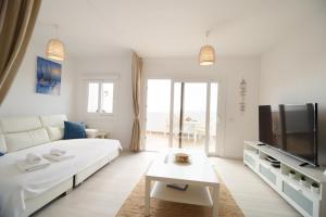 sala de estar blanca con sofá blanco y TV en Elita veradero Nice FREE WIFI, en Puerto de Santiago