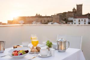 a table with a bowl of food and a glass of orange juice at Dorma Agora Cáceres in Cáceres