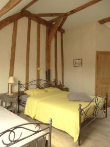 two beds in a room with wooden beams at La Vannerie in Origny-en-Thiérache