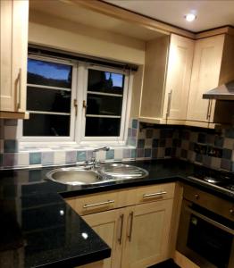 eine Küche mit einem Waschbecken und einem Fenster in der Unterkunft Gorgeview Cottage in Ironbridge
