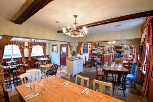 a restaurant with wooden tables and chairs and a chandelier at The Coach and Horses in Worthing