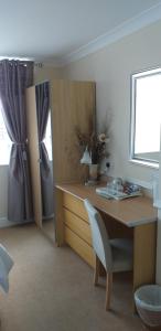 a room with a desk with a chair and a window at Surrey House Hotel in Blackpool