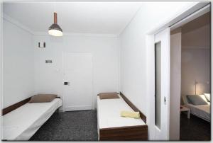 Habitación blanca con 2 camas y sofá en Anni's apartments 50m from the beach, en Agia Triada