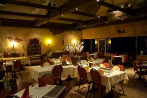 een eetkamer met tafels en stoelen met witte tafelkleden bij Hotel & Restaurant 'T Holt in Diepenheim