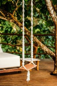 a swing on a porch with a tree at La Cabane in Jimbaran