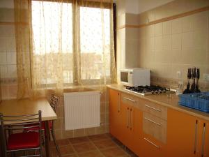 a kitchen with a stove and a window and a table at Villa Edera Residence - Gazda Profesionista in Bucharest