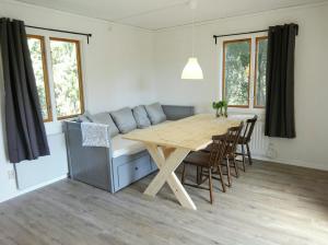 a dining room with a wooden table and chairs at Ålebro stugby in Norrhult