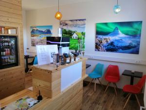 a coffee shop with red and blue chairs at Lyngás Guesthouse in Egilsstaðir