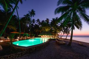 ein Schwimmbad am Strand in der Nacht in der Unterkunft Calala Island in Set Net