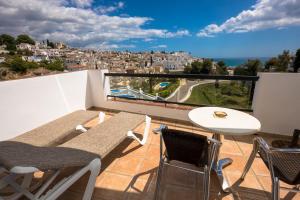 a balcony with a table and chairs and a view at Hostal Casa Mercedes in Nerja