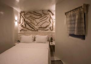 a small room with a bed and a stone wall at Milos Maison in (( Kermetés ))