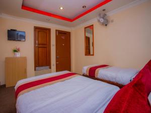 a hotel room with two beds and two lamps at OYO 305 Hotel Gauri in Pashupatināth