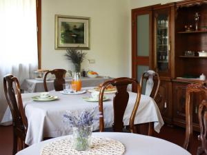 una sala da pranzo con 2 tavoli e una tovaglia bianca di Bed And Breakfast 22 Garibaldi Home a Riccione