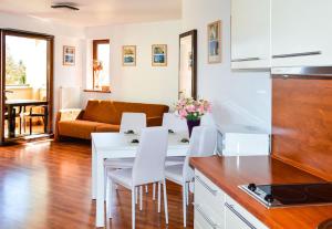 Przystań przy plaży في فواديسوافوفو: مطبخ وغرفة معيشة مع طاولة وكراسي بيضاء