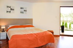 Przystań przy plaży في فواديسوافوفو: غرفة نوم مع سرير وبطانية برتقالية