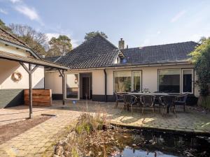 een huis met een patio met een tafel en stoelen bij Koetshuis Nunspeet in Nunspeet