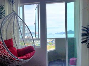 a swing in a room with a view of the ocean at Langkawi M seaview Apartment in Kuah